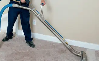 Professional operating a liquid removal machine on a carpeted floor in Long Beach, CA